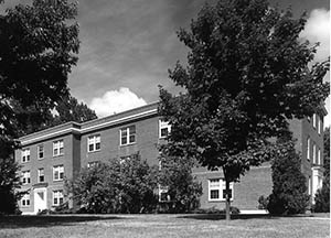 Alexander Hall from Mill Road with trees in foreground.