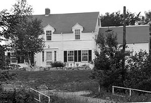 Elizabeth DeMeritt House with trees and gate in foreground.