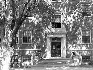 Courtyard entrance to Murkland Hall with students sitting on steps and looking out windows.