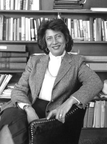 Photo of Evelyn Handler in front of bookshelf