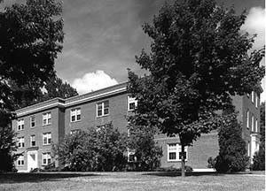 Alexander Hall from Mill Road with trees in foreground.